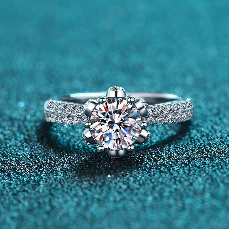 Silver ring with a large diamond on a teal textured background