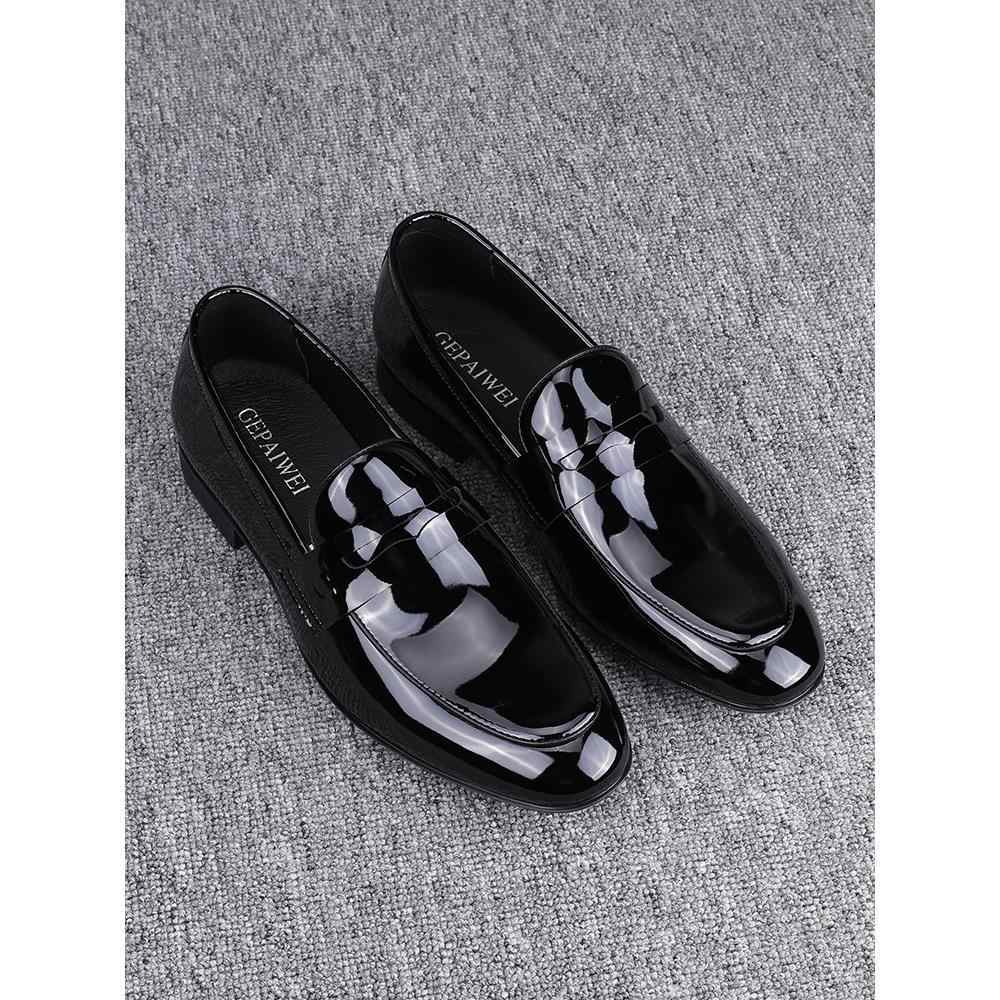 Black glossy loafers on a textured gray surface