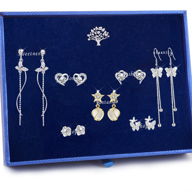 Collection of silver and gold earrings on a blue velvet background