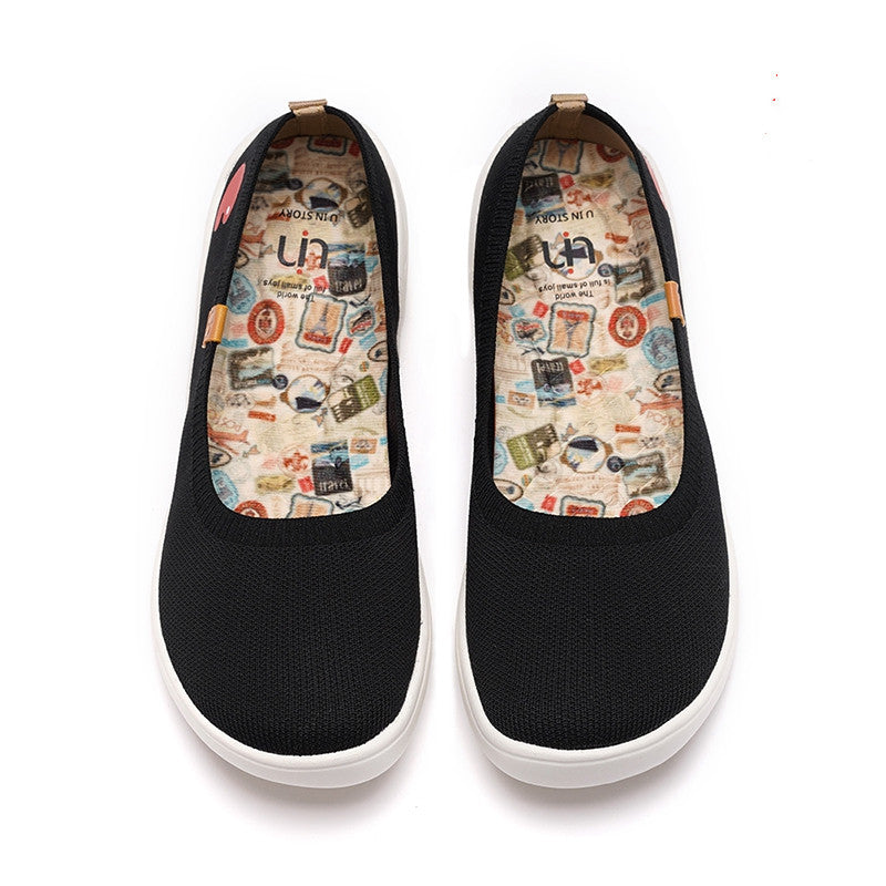 Black slip-on shoes with patterned insoles on a white background