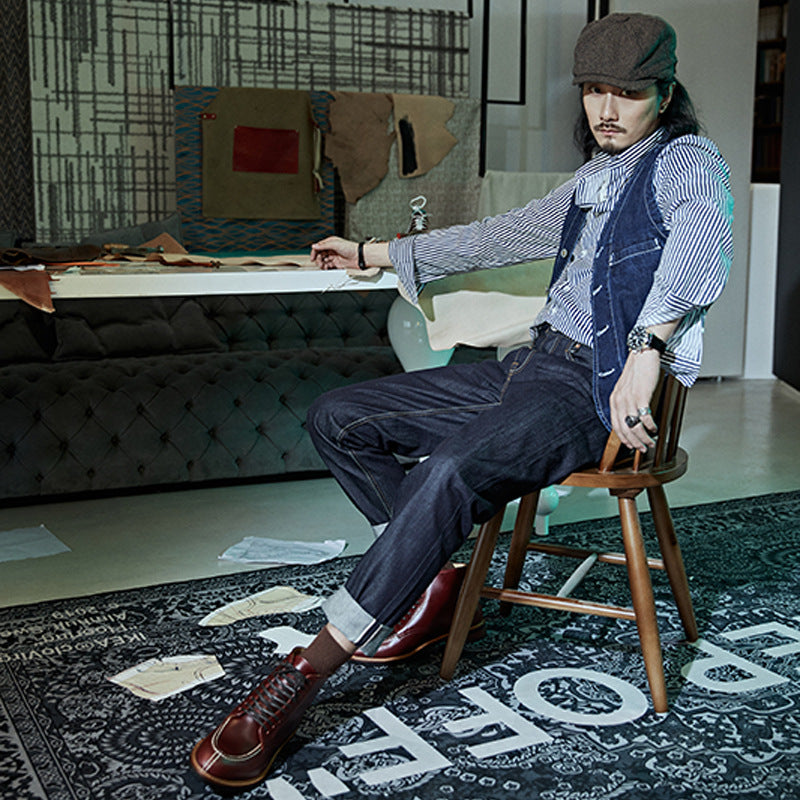 Man sitting on a chair in a room with a patterned rug and textured walls.