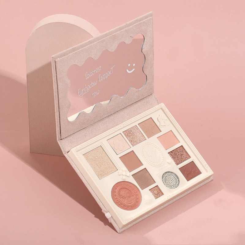 Makeup palette with various shades on a pink background