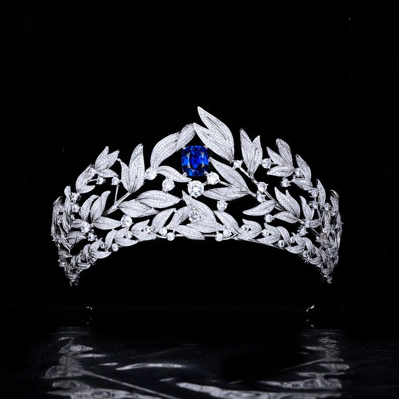 Silver tiara with a blue gemstone on a black background