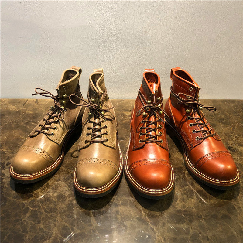 Pair of brown leather boots on a textured surface with a neutral background