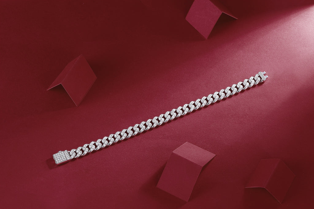 Silver bracelet on a red surface with geometric shapes