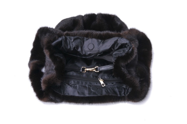 Black fur-lined handbag with visible branding on a white background