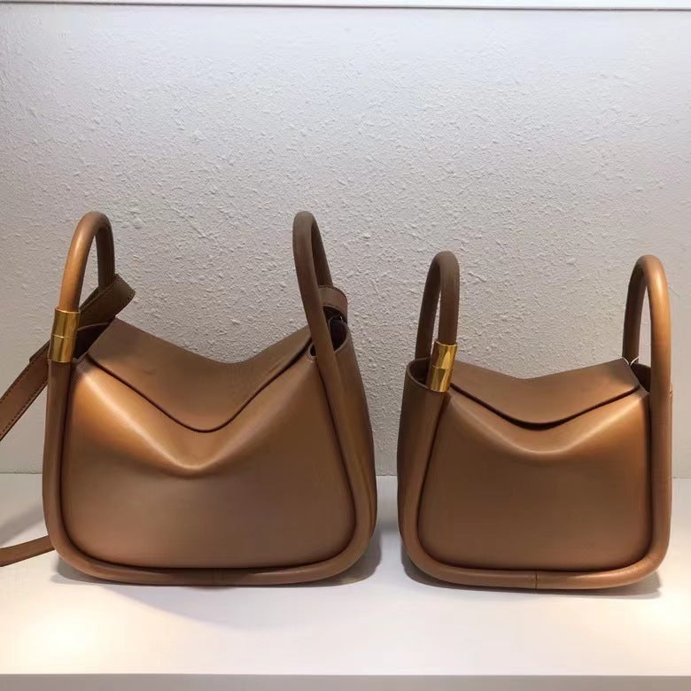 Two brown handbags with gold accents on a white background