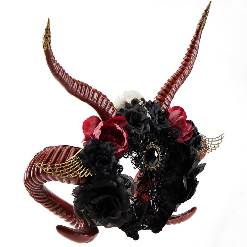 Decorative headband with red and black horns, flowers, and feathers on a white background
