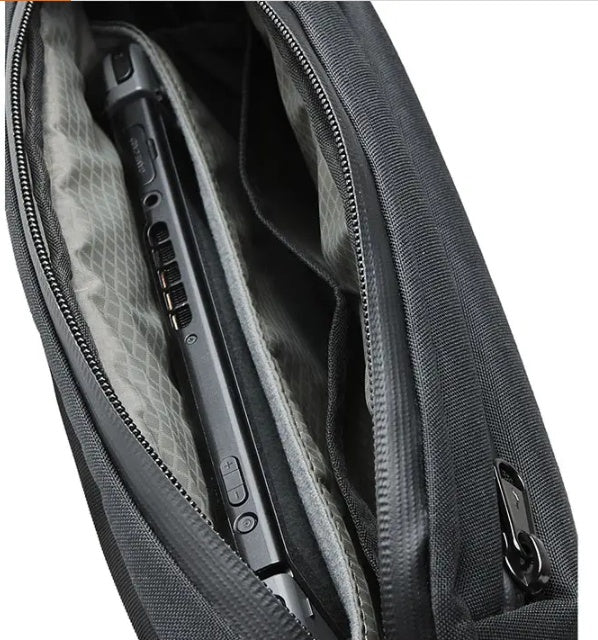 Gray backpack with a laptop inside, showing the interior compartment.