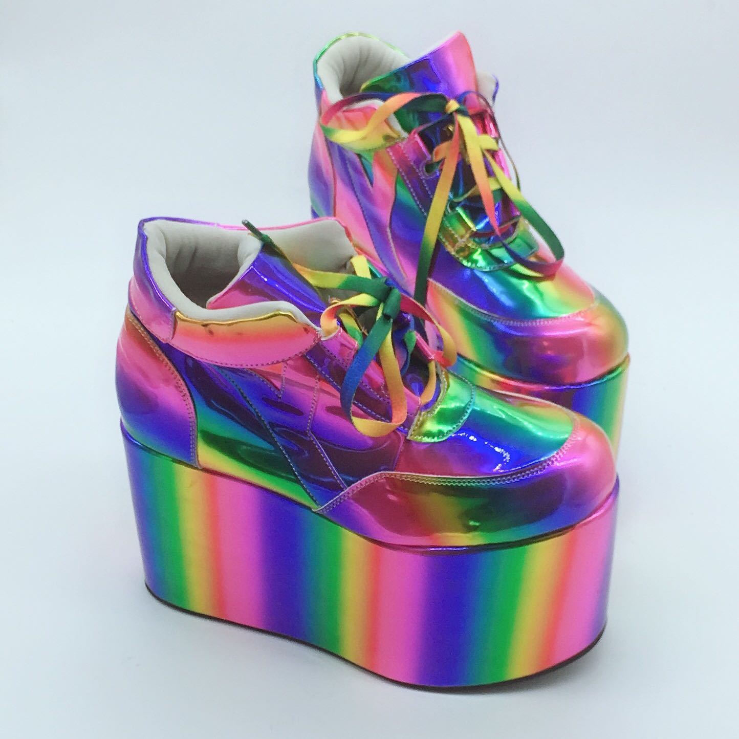 Multicolored platform shoes with rainbow stripes on a light gray background