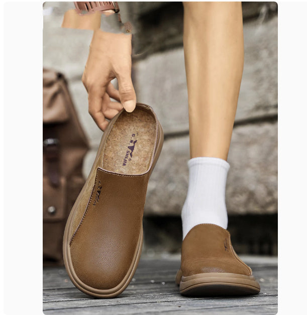 Brown leather shoe with a visible brand logo, worn with white socks on a blurred background.