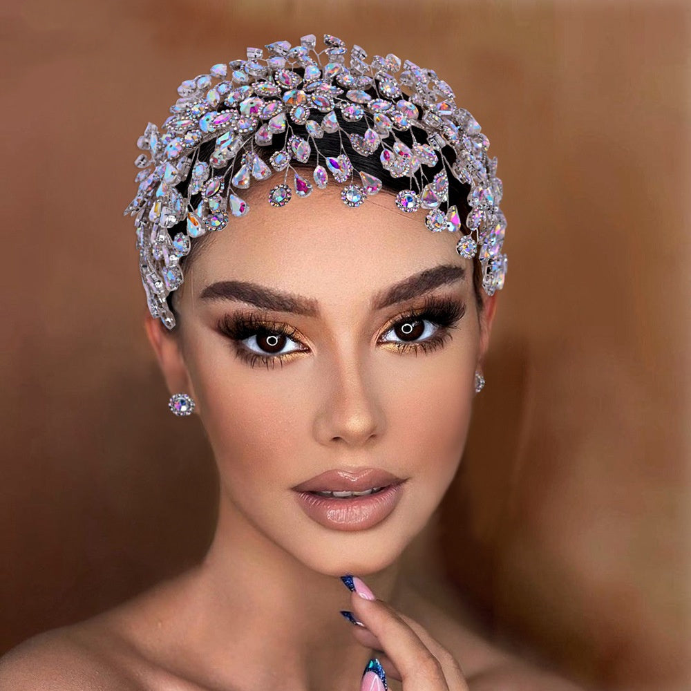 Woman wearing a sparkling diamond headpiece against a brown background