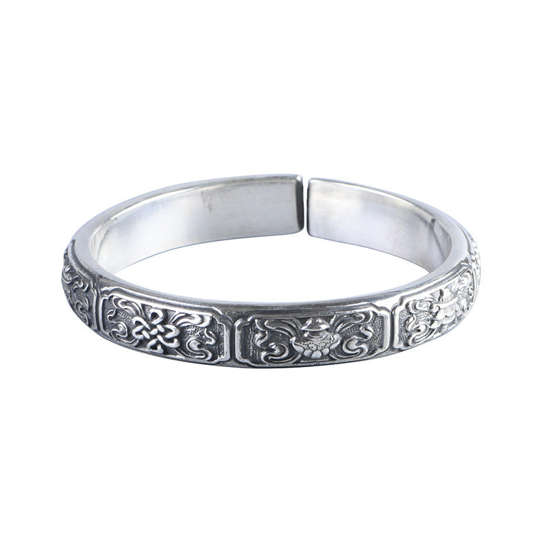 Silver bracelet with intricate designs on a white background
