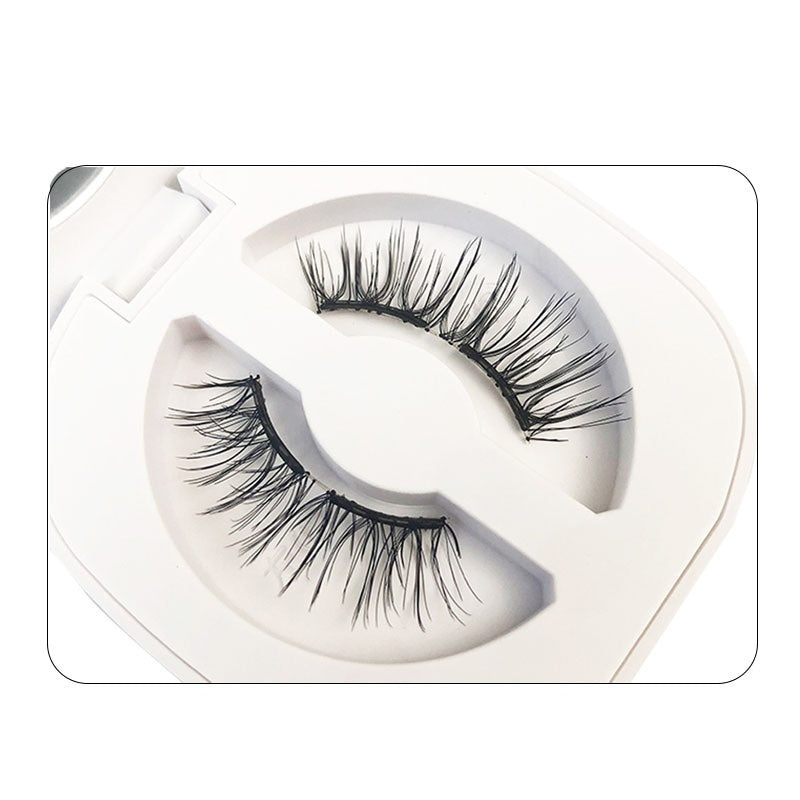 Pair of false eyelashes in a white tray on a white background