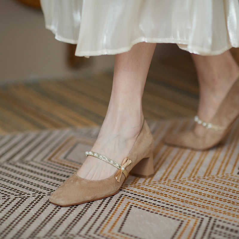 Brown shoes with decorative bows worn by a person on a patterned rug.