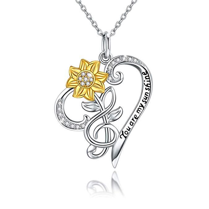 Necklace with a gold flower and silver heart pendant on a white background