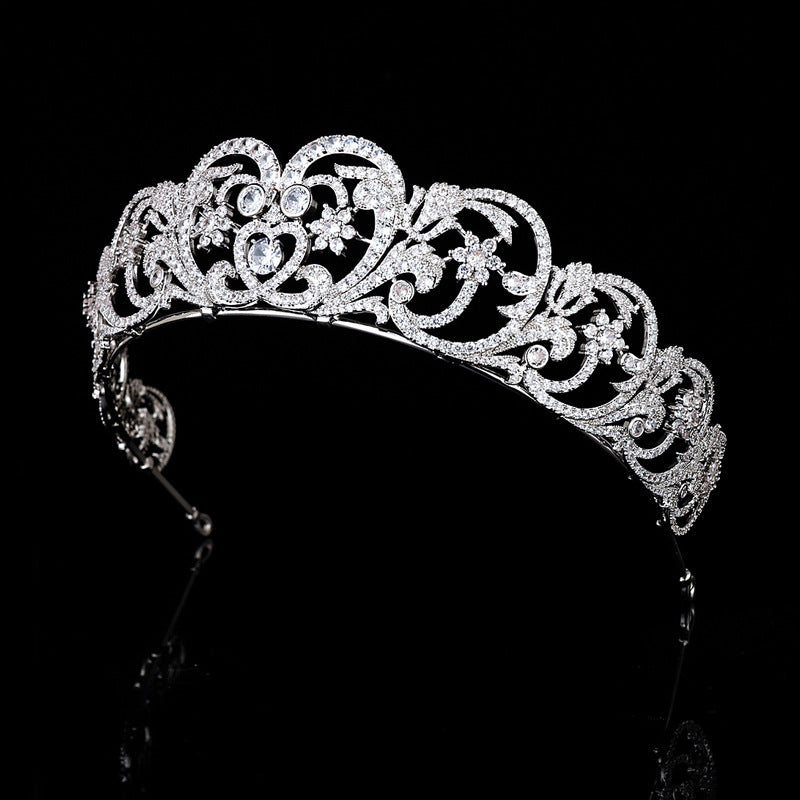 Silver tiara with intricate design on a black background