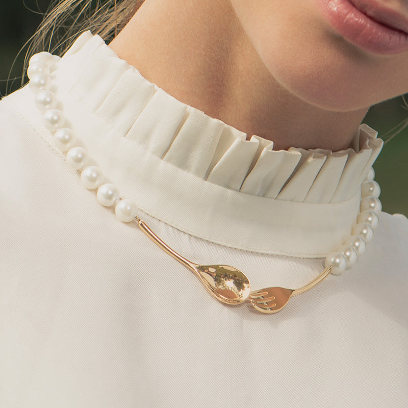 Pearl necklace with a gold pendant worn by a person