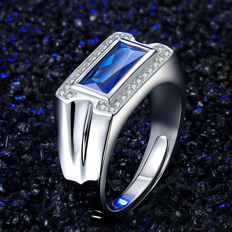 Silver ring with a blue gemstone on a dark, textured background