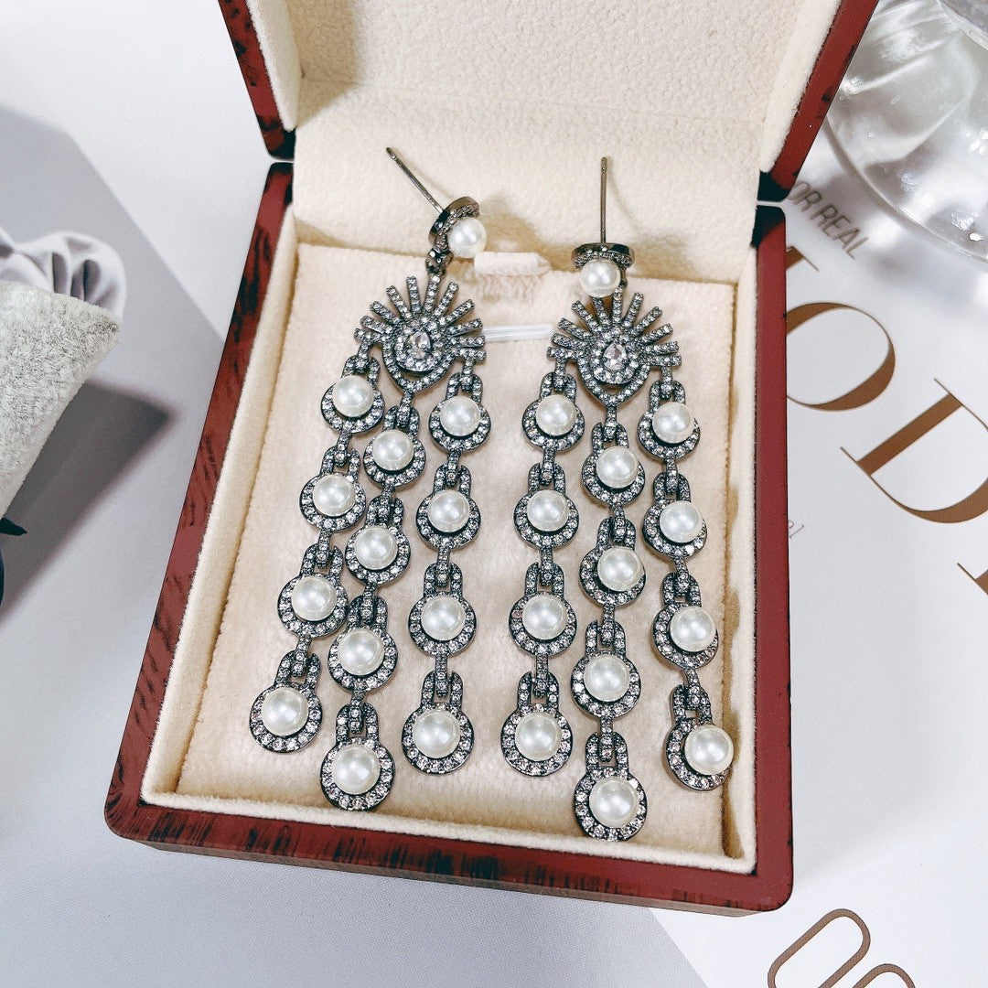 Pair of ornate earrings with pearls in a jewelry box on a magazine background