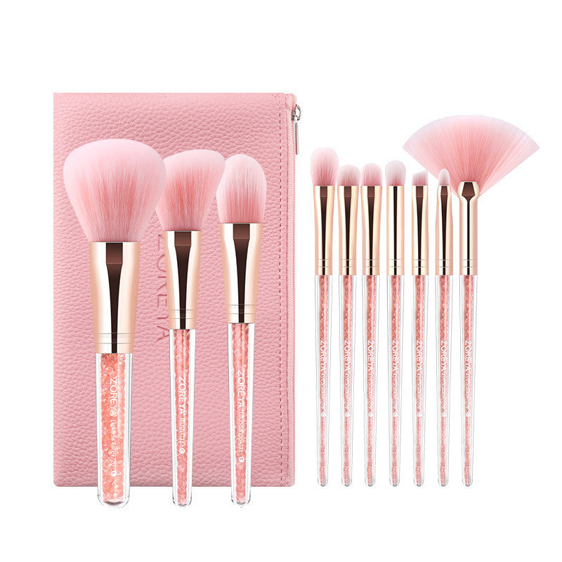 Makeup brush set with pink bristles and rose gold handles, including a pink case.