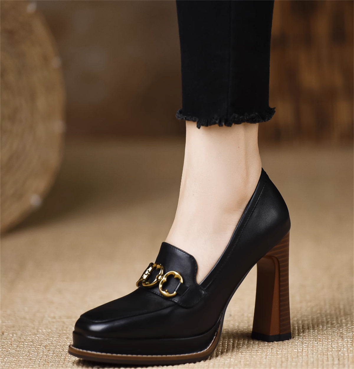 Black leather shoe with gold buckle on a blurred background