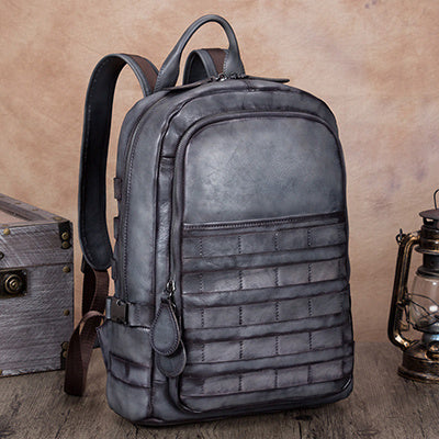 Gray backpack with tactical design on a wooden surface with vintage items.