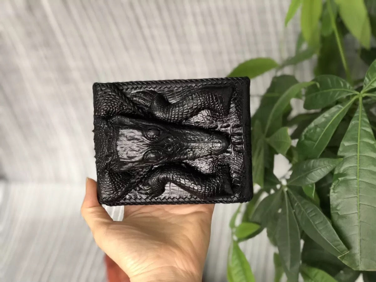Black textured wallet held by a hand with a blurred background