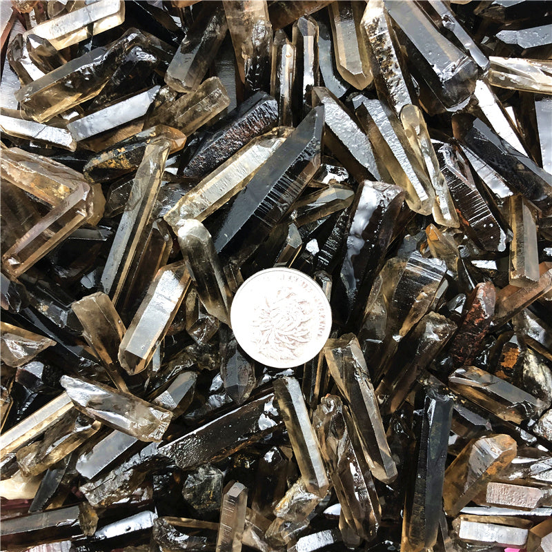 Close-up of metallic crystals with a coin for scale