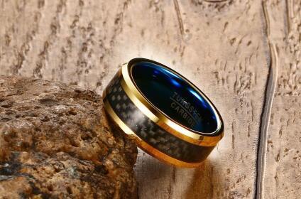 Gold and black ring with blue interior on a wooden surface