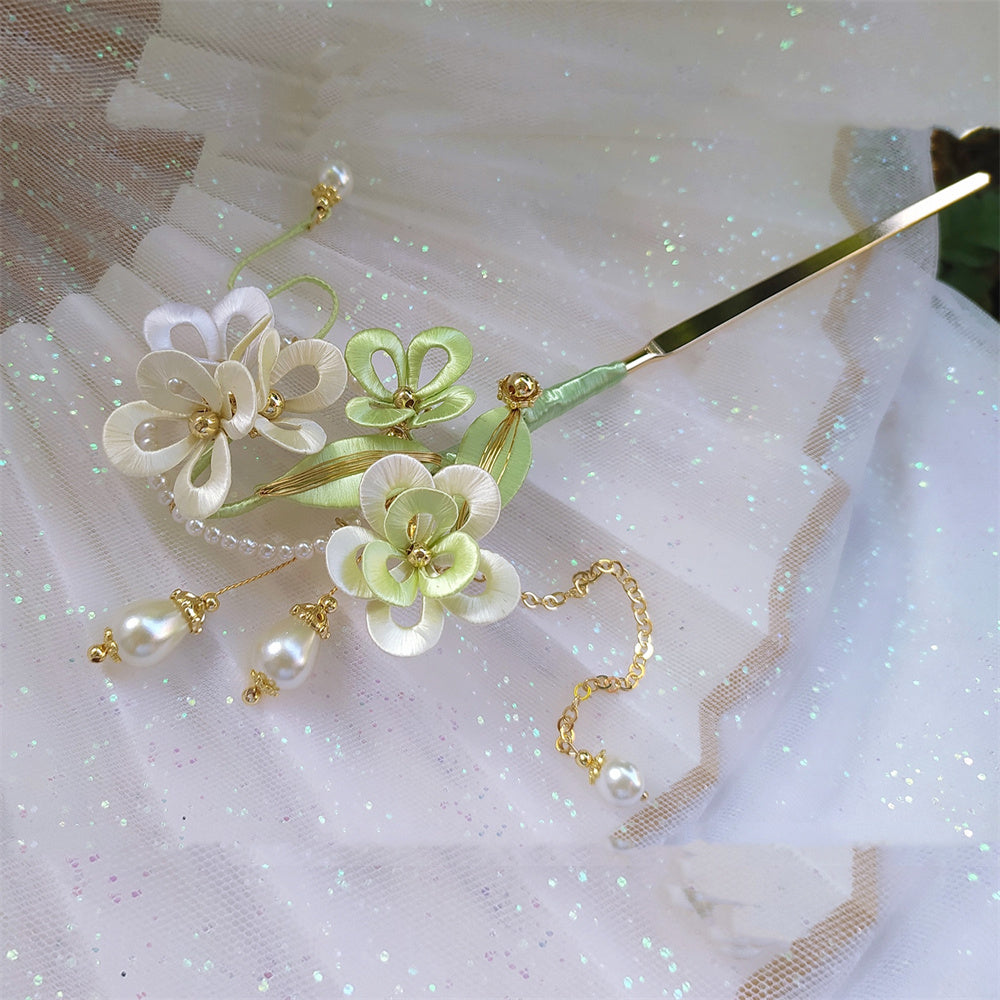 Decorative hairpin with flowers and pearls on a white fabric background