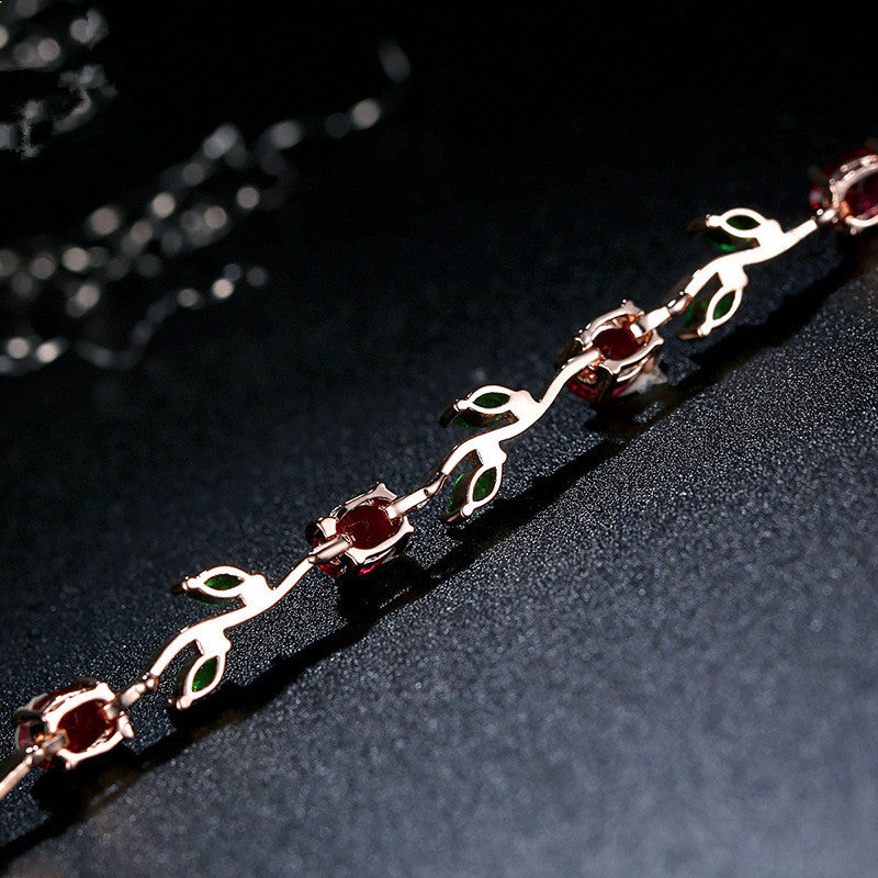 Silver bracelet with red gemstones on a dark surface