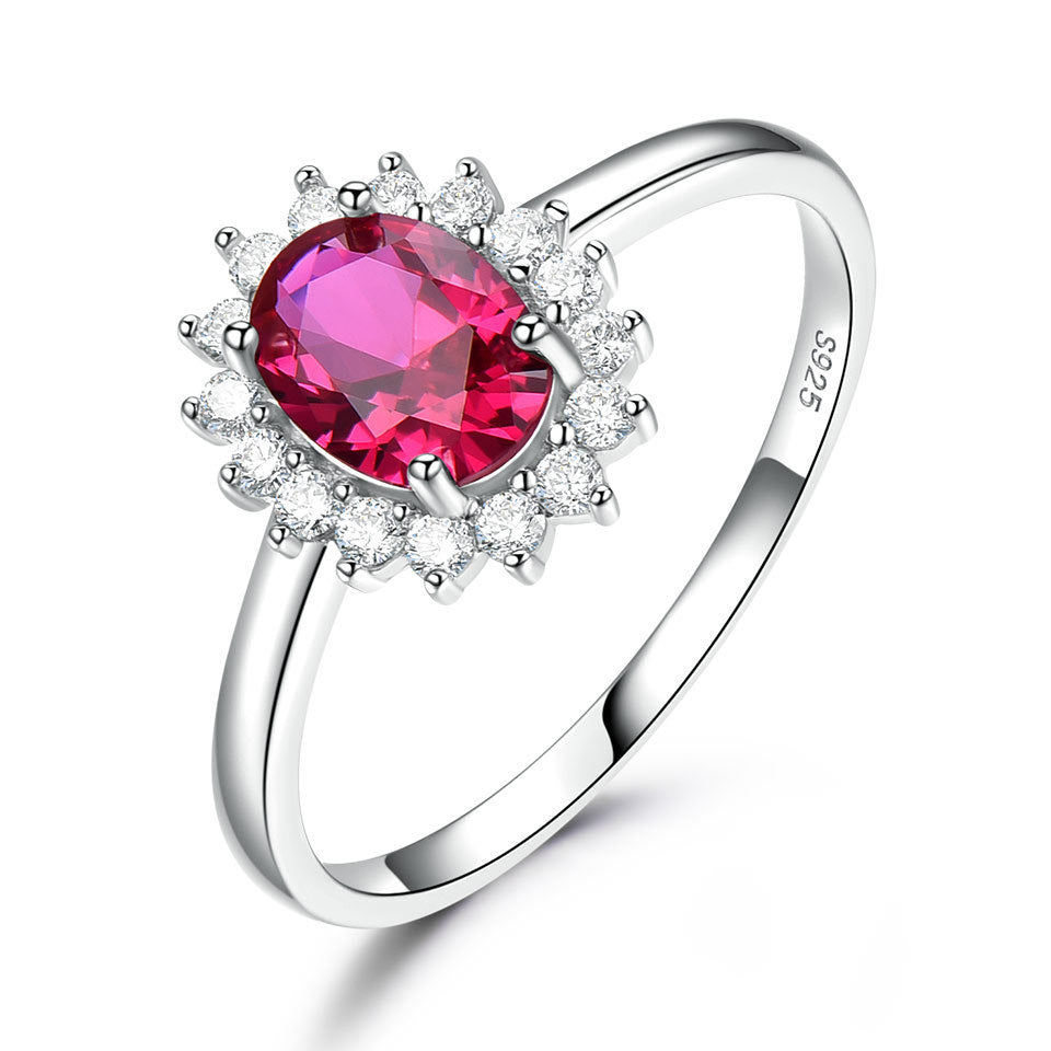 Silver ring with a red gemstone on a white background