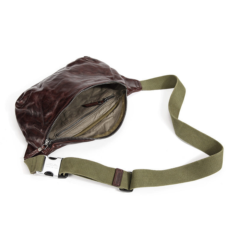 Brown leather waist bag with green strap on a white background