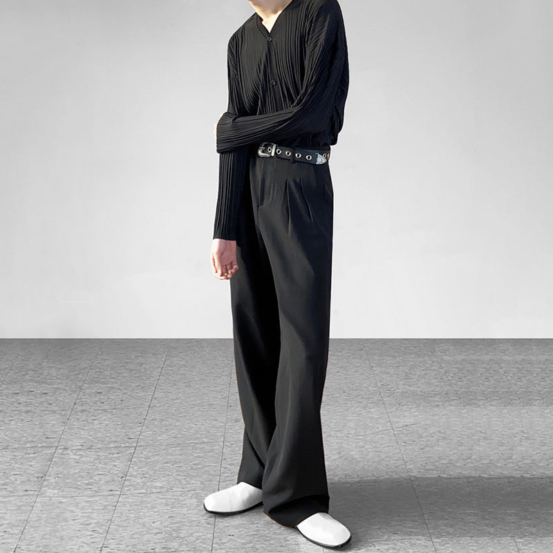 Person wearing a black outfit with wide-leg pants on a plain background