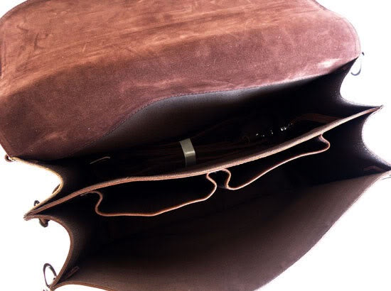 Brown leather bag with a pen inside on a white background