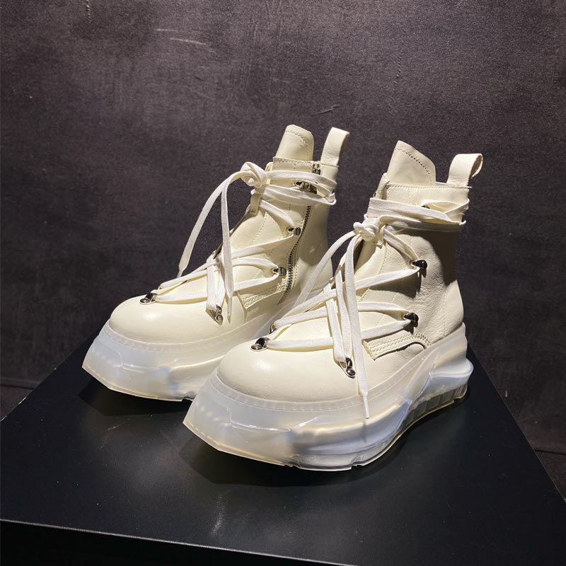White high-top sneakers with transparent soles on a black surface and background
