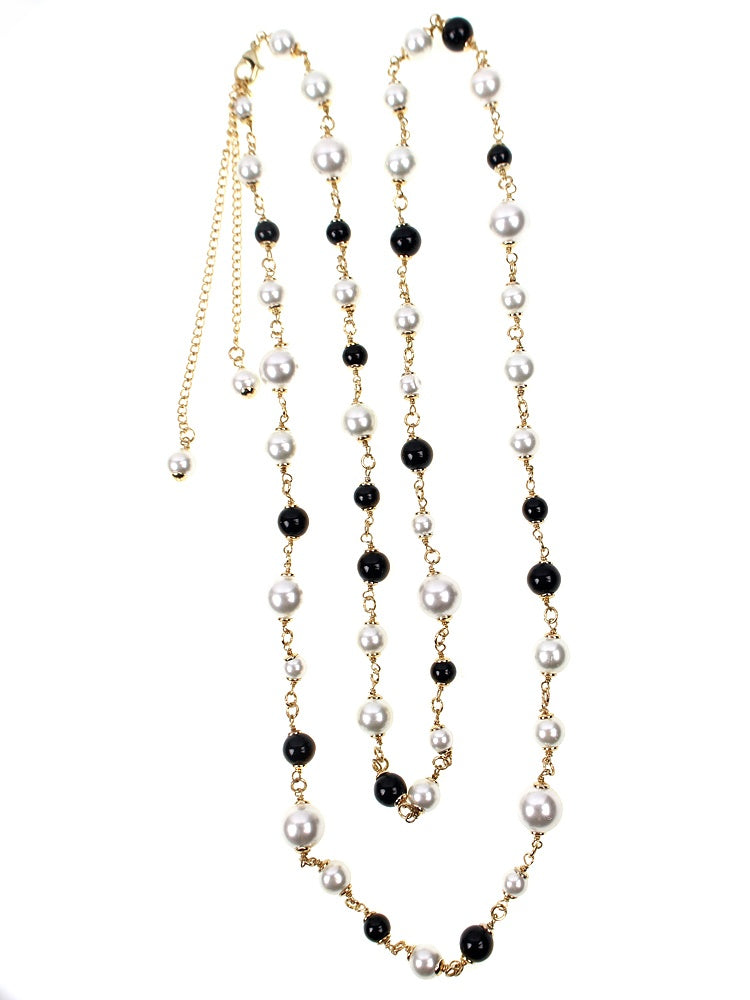 Long necklace with pearls and black beads on a white background