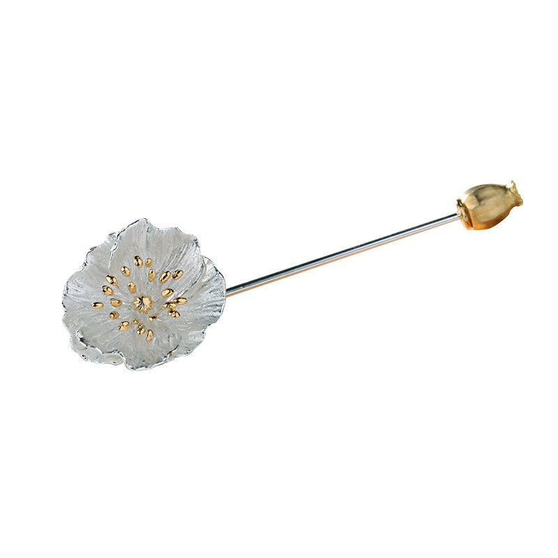 Floral brooch with gold accents on a white background