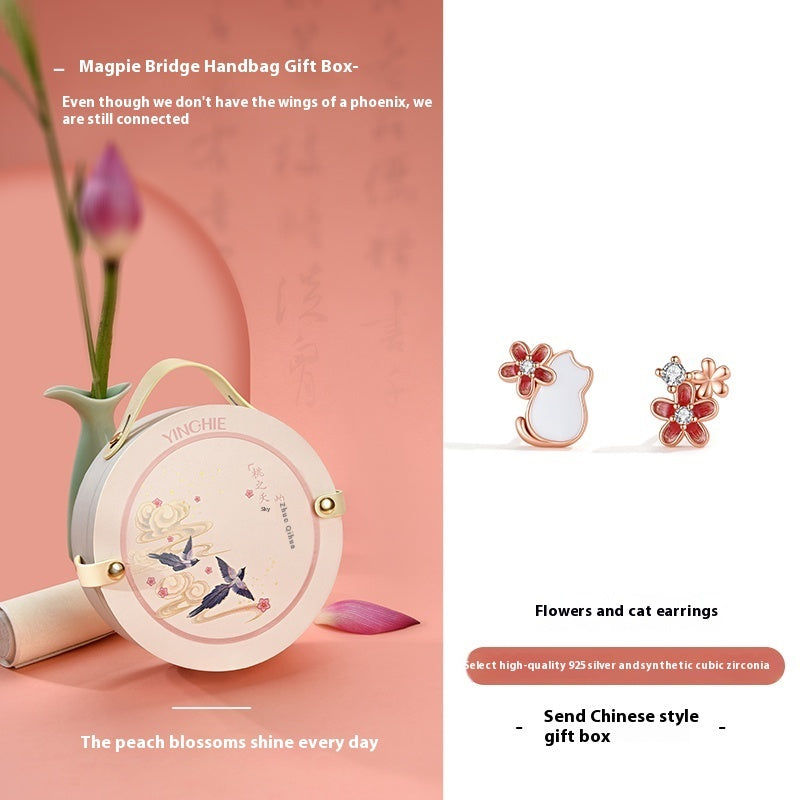 YUECHI handbag gift box with flowers and cat earrings on a pink background