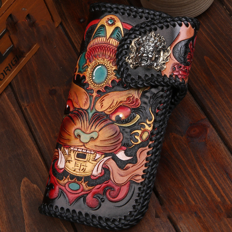 Decorative leather wallet with intricate designs on a wooden surface