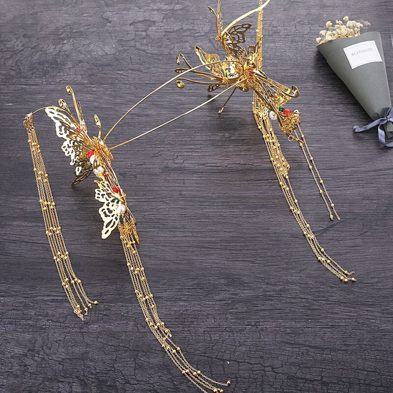 Gold butterfly hair accessories on a dark wooden surface