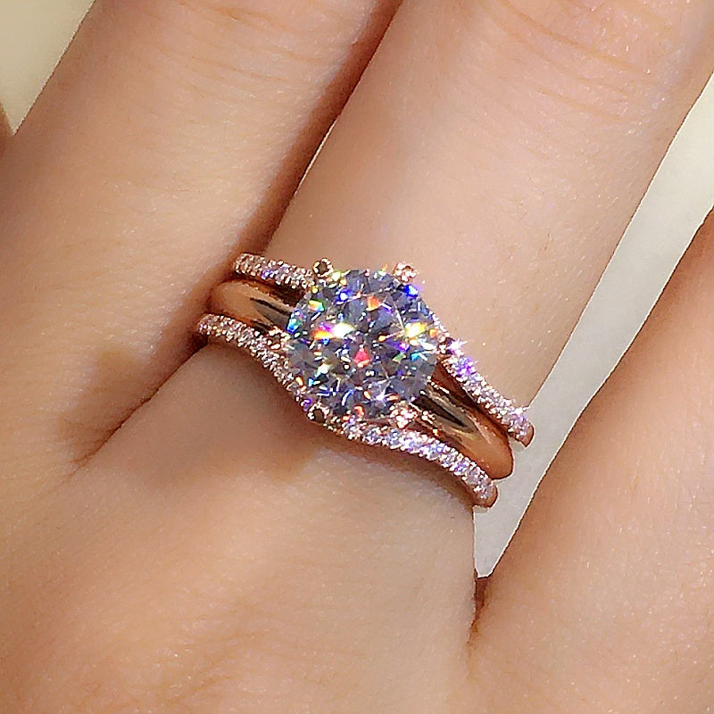 Rose gold ring with a large diamond on a finger against a neutral background