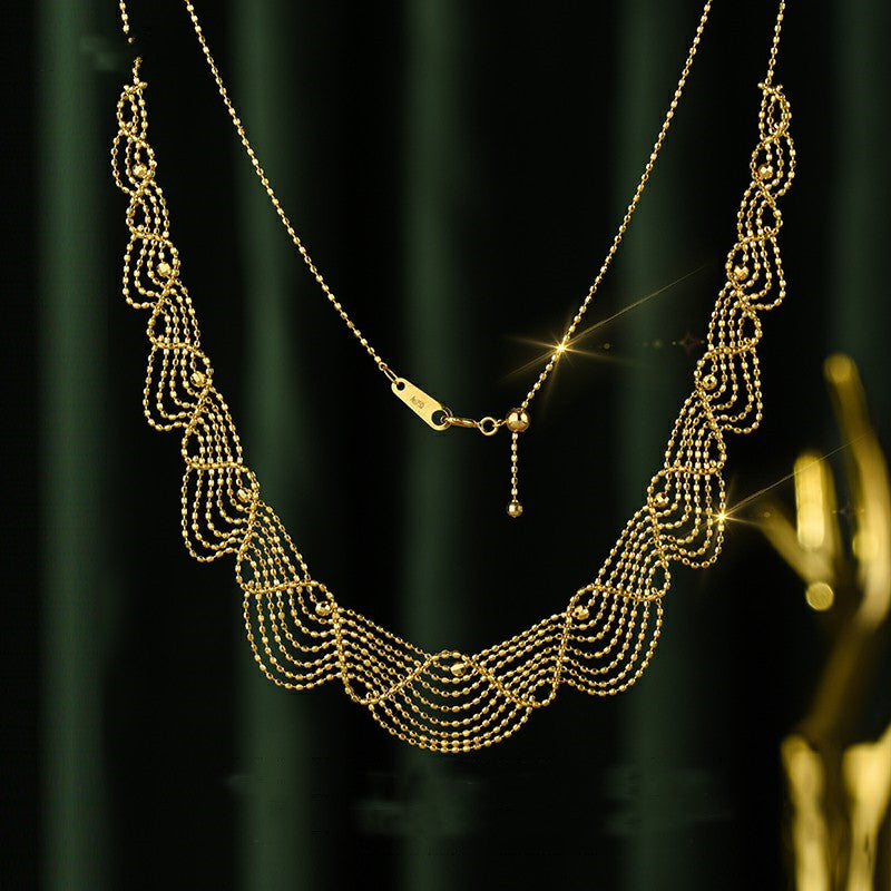 Gold necklace with intricate design on a dark green background