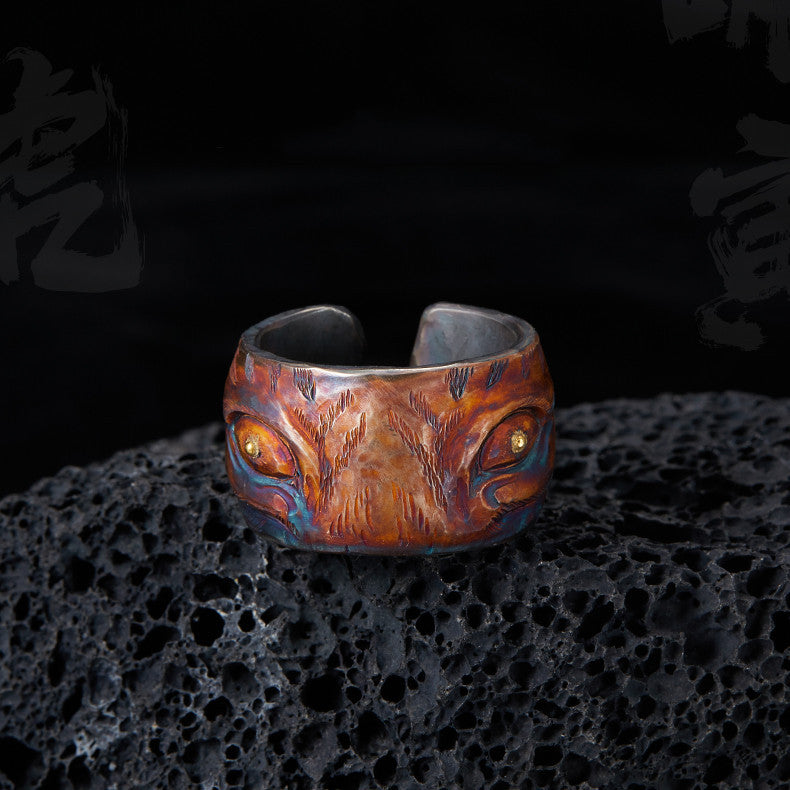 Wooden ring with metal accents on a textured black surface