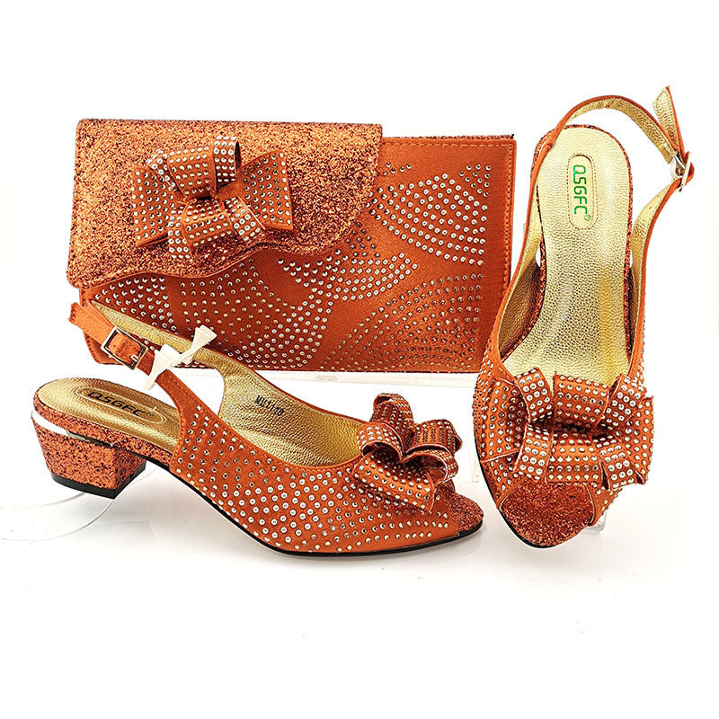Orange shoes and matching handbag with decorative elements on a white background