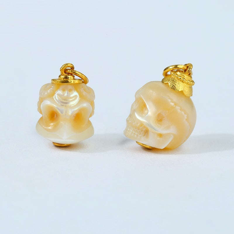 Skull-shaped earrings with gold accents on a light gray background