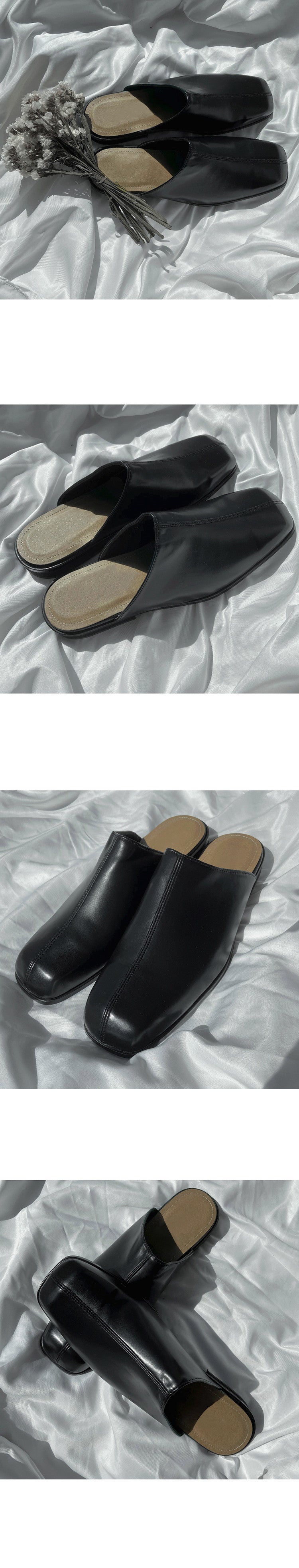 Black clogs with beige soles on a textured white surface