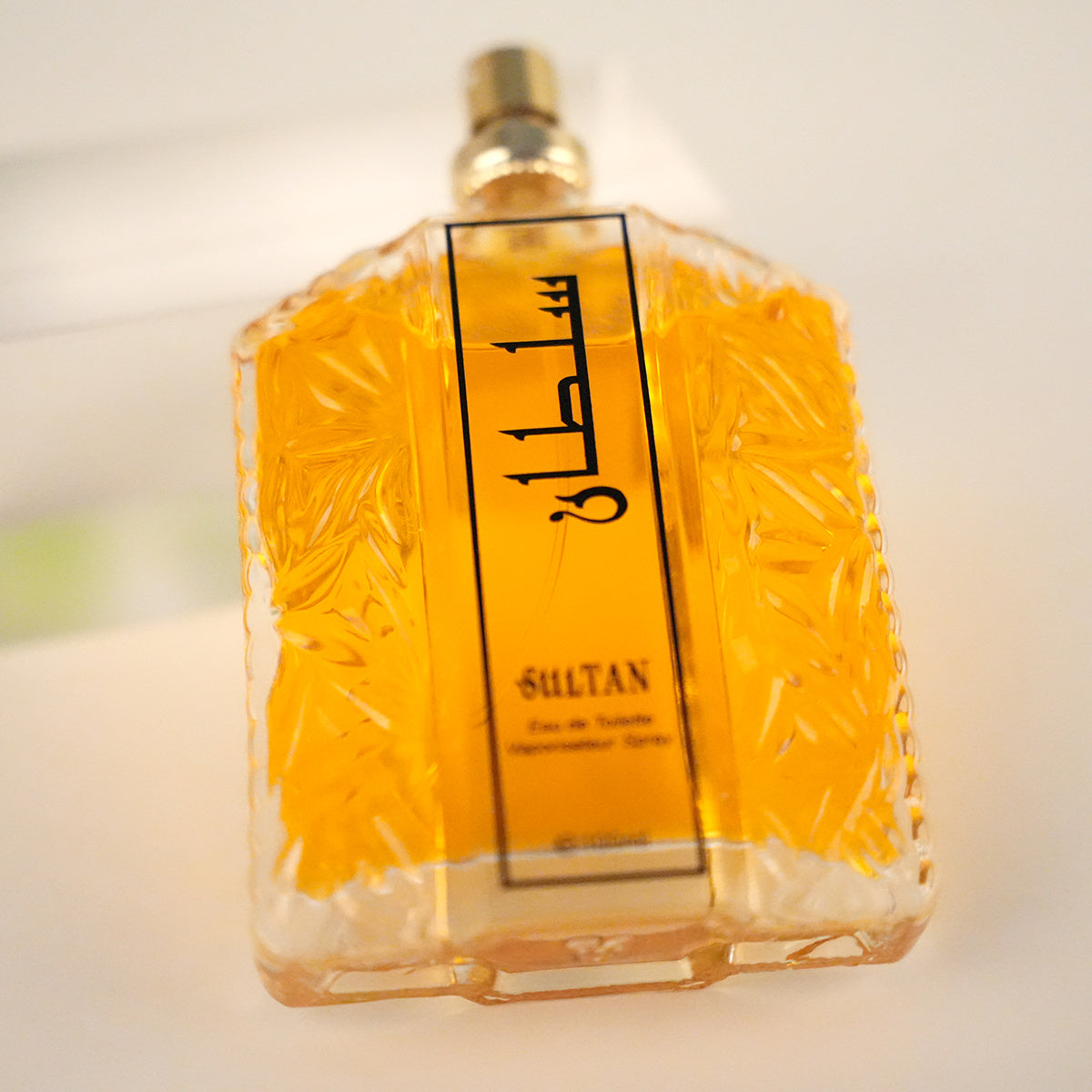 Perfume bottle labeled 'Sultan' with a textured design on a light background