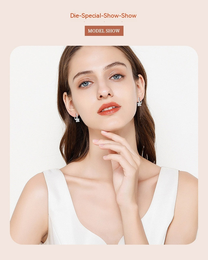 Woman wearing earrings with a plain background